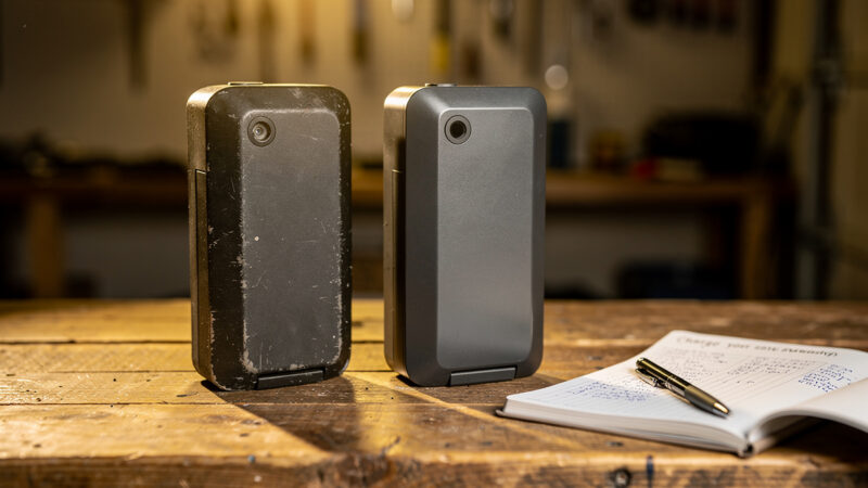 An older and a newer e-bike battery pack side by side on a workbench with charge logs