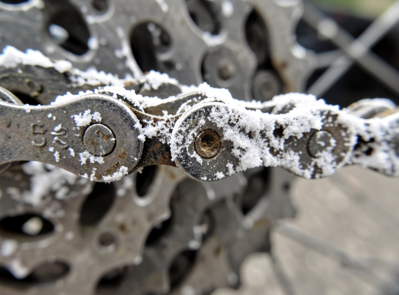 Salt residue crusted on an e-bike chain and rear derailleur after a winter ride