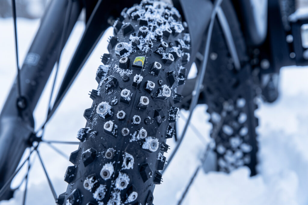 Studded winter e-bike tire with carbide studs against snow
